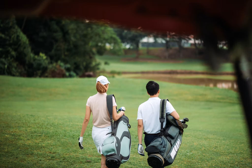 Wie viele Golfstunden Anfänger: Golf Anfänger beim Training mit Trainer auf dem Golfplatz